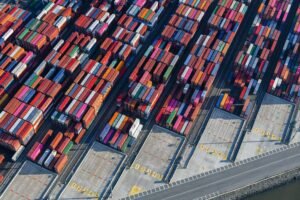 Aerial shot of colorful cargo containers at a bustling New York port, showcasing global trade.